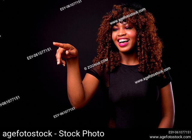 Studio shot of young beautiful African woman against black background