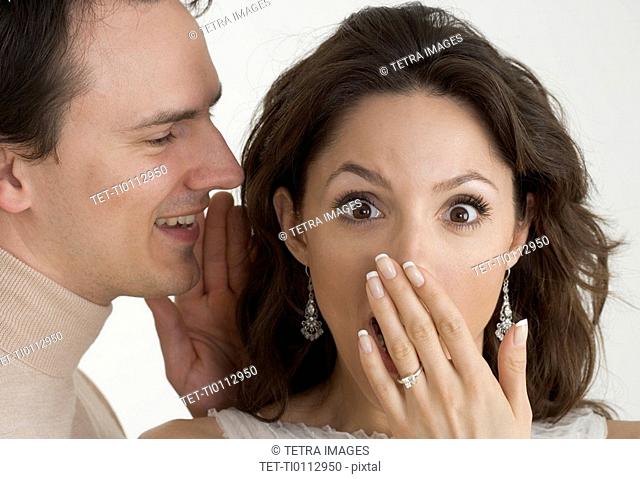 Man telling woman a surprising secret
