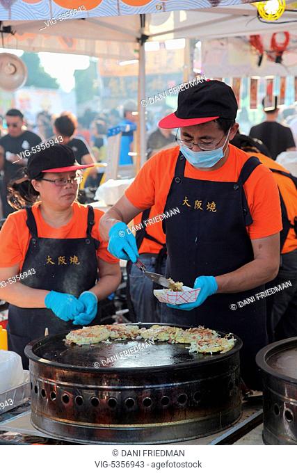 CANADA, MARKHAM, 24.07.2015, Food vendors preparing Okonomiyaki (Japanese pancakes containing a variety of ingredients) during an all-night Chinese market held...