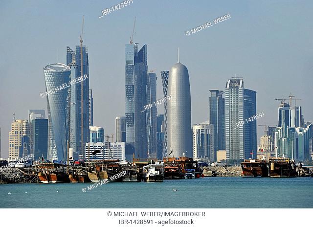 Tradition and modernity, dhow wooden cargo ships in front of the skyline of Doha, Qatar, Persian Gulf, Middle East, Asia