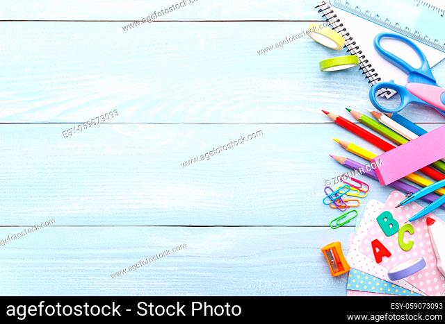 Back to school concept, with colorful stationery for kids on blue wooden background copy space
