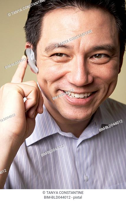 Asian man wearing hands free device