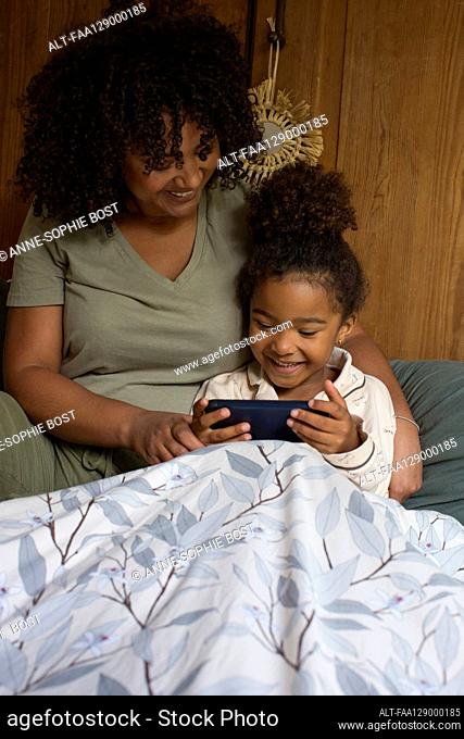 Daughter and mother using smart phone