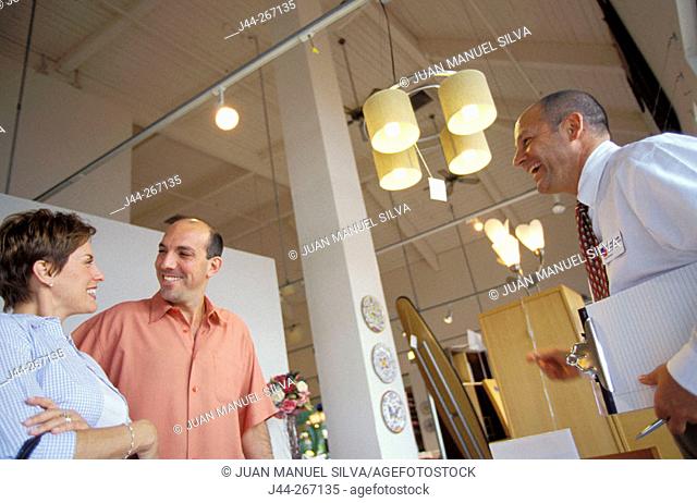 Couple and salesman in furniture shop
