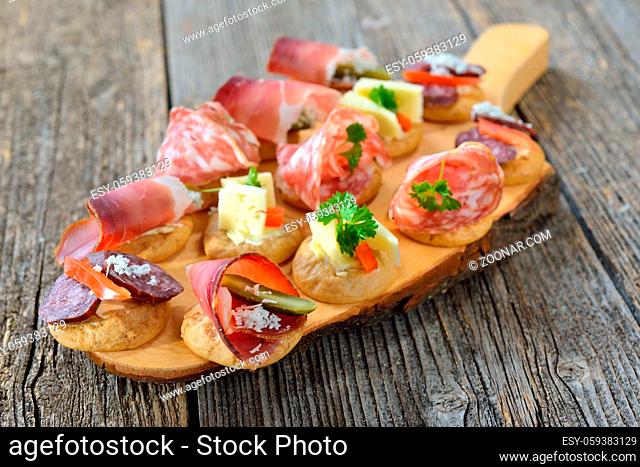 Südtiroler Fingerfood: Schüttelbrot-Häppchen mit Speck, Lagrein Weinkäse, Bauernsalami und Kaminwurzen - South Tyrolean appetizers: Crunchy rye bread with bacon