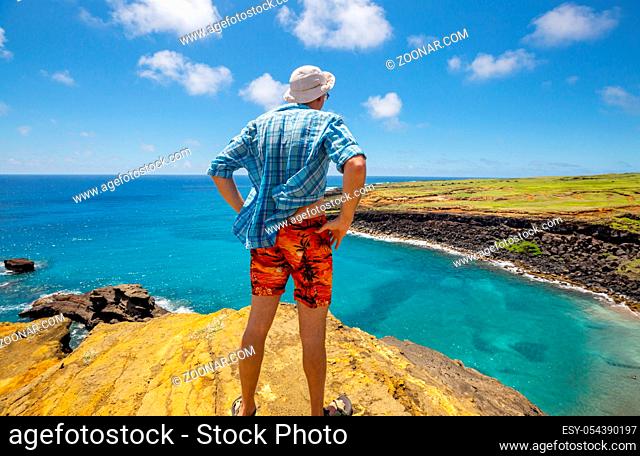 Tourist standing a top a cliff overlooking, Big island Hawaii's