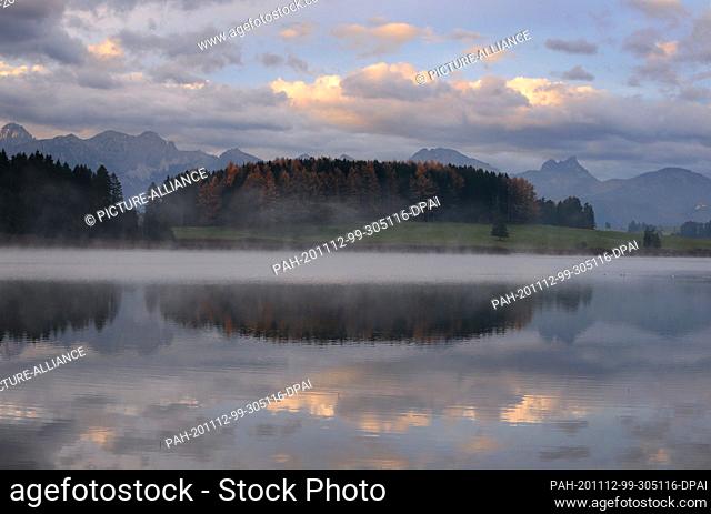 12 November 2020, Bavaria, Roßhaupten: In the morning fog the Illasberg Lake lies in front of the panorama of the Alps. Photo: Karl-Josef Hildenbrand/dpa