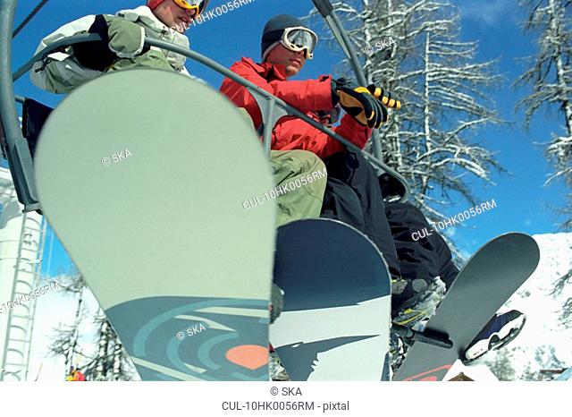 2 males riding on chair lift