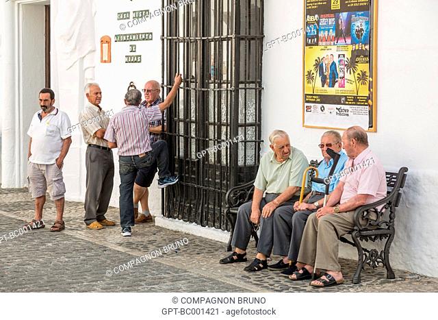 SPANISH MEN HAVING A DISCUSSION IN THE STREETS OF MIJAS, COSTA DEL SOL, THE SUNNY COAST, ANDALUSIA, SPAIN