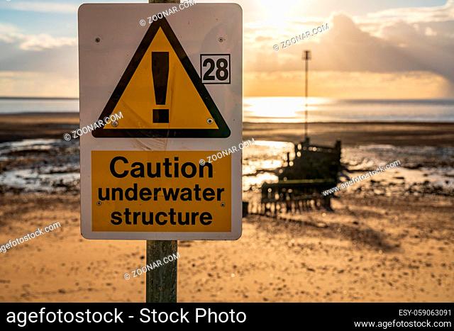 Sign: Caution, Underwater Structure, seen at the North Beach in Heacham, Norfolk, England, UK