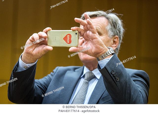 Former manager of Deutsche Bahn, Hartmut Mehdorn, takes photos of the waiting journalists with his smartphone at the Landcourt in Bochum, Germany