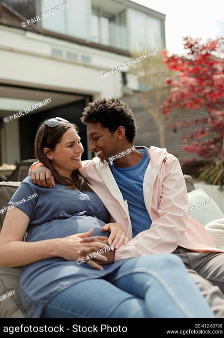 Happy affectionate pregnant couple on patio
