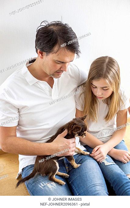 Father and daughter playing with dog