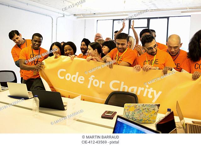 Hackers with banner coding for charity at hackathon
