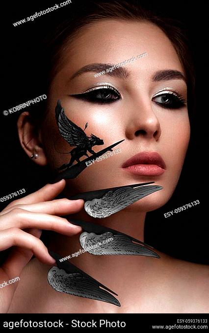 Beautiful woman with art make-up, creative long nails. Design manicure. Beauty face. Picture taken in the studio