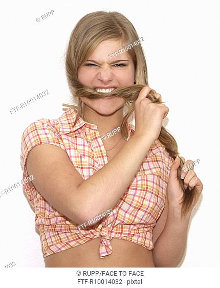 Blond woman biting in her hair