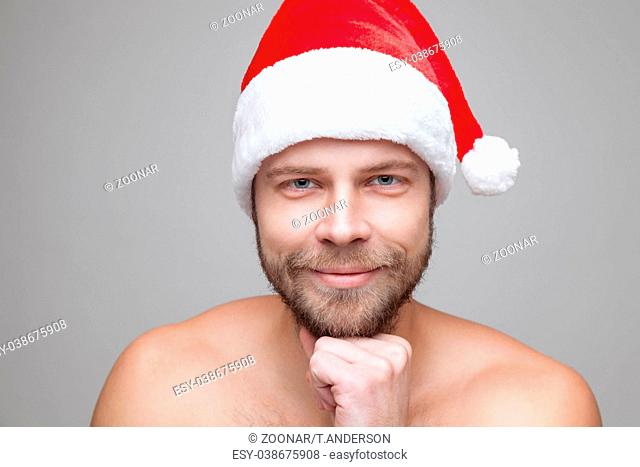 Portrait of a handsome man with beard wearing a Christmas hat