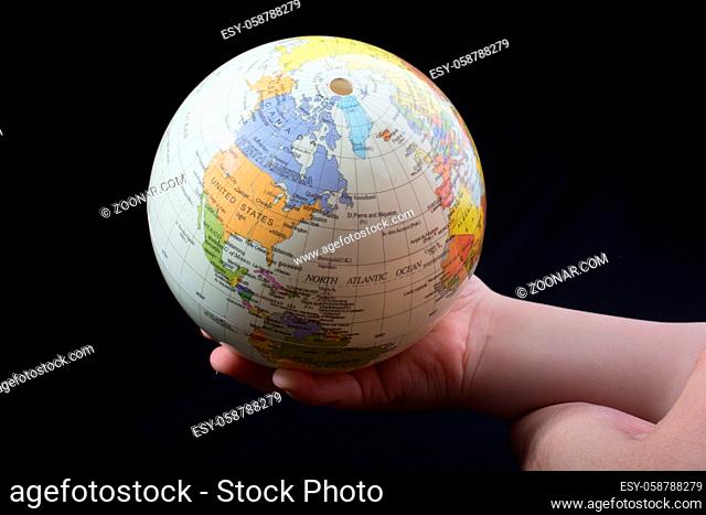 Hand holding a globe with map on it