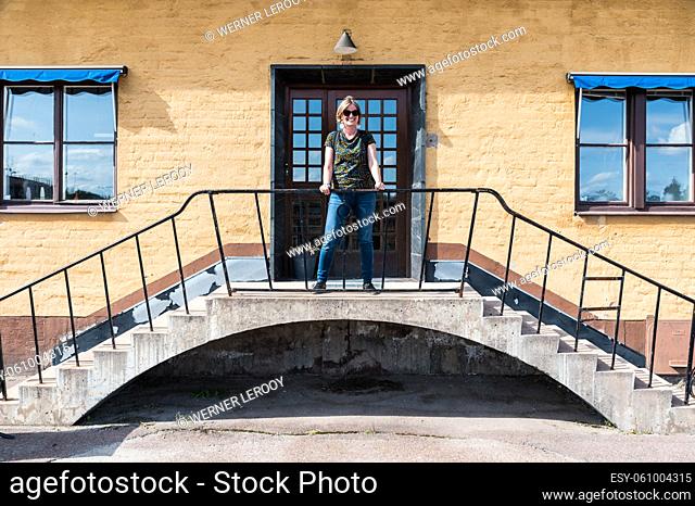 Falun, Dalarna - Sweden - 08 05 2019 Woman standing on a yellow facade house of the museum
