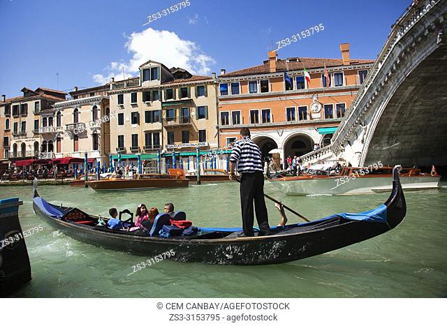 Gondola carrying tourists near Rialto bridge, Venice, Veneto, Italy, Europe