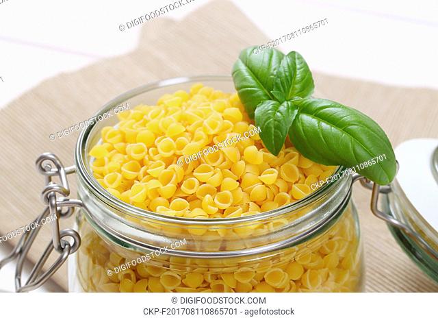 jar of small pasta shells on beige place mat - close up