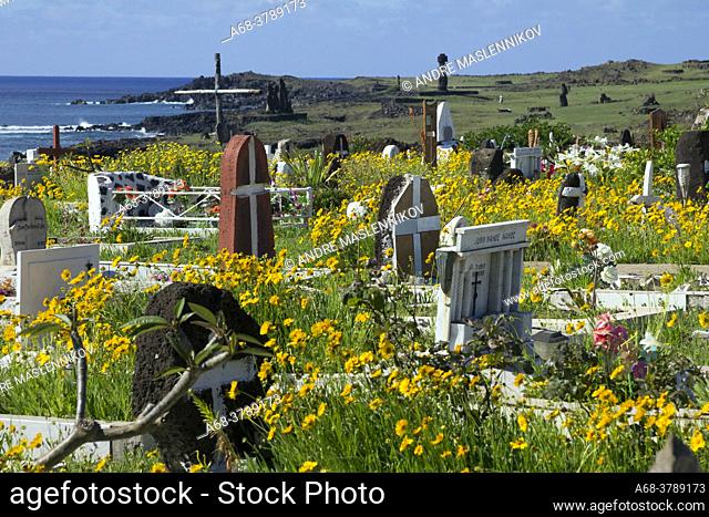 The cemetery of the village Hanga Roa on Easter Island. Several Moai statues can be seen behind