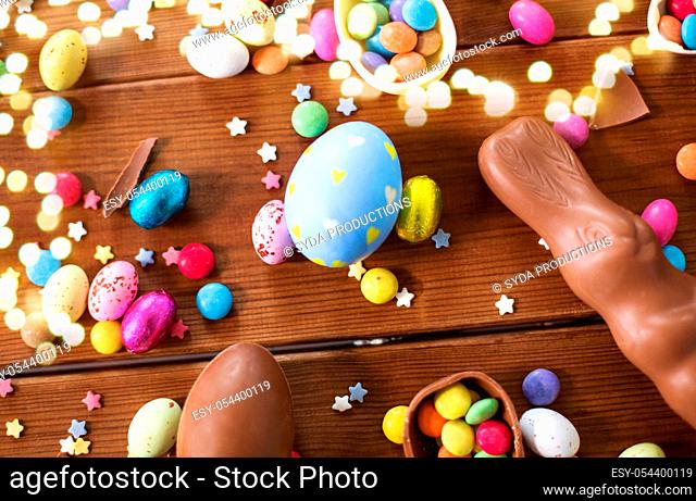 chocolate eggs, easter bunny and candies on wood
