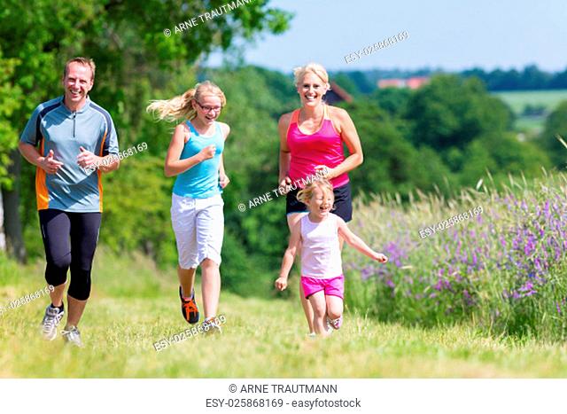 Eltern und Töchter joggen gemeinsam durch den Wald