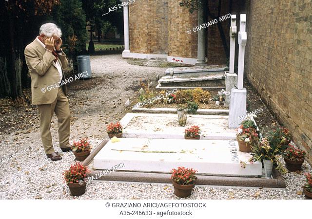 Leonard Bernstein stands in front of Igor Stravinsky's tomb at the cemetery on the island of San Michele in Venice
