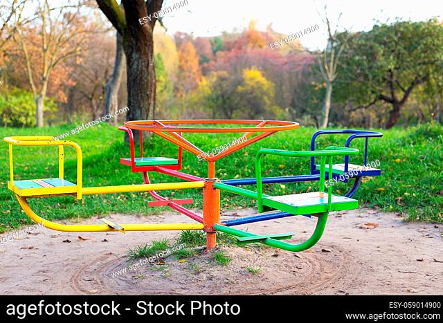 A bright playground surrounded by greenery, many different children's swings, a beautiful and cozy park for relaxation