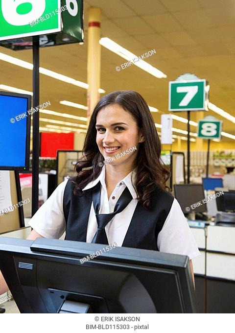 Caucasian cashier at grocery store checkout