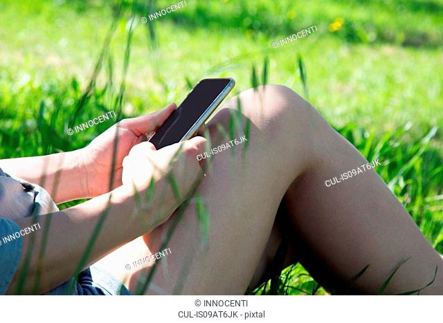 Cropped view of young woman using smartphone