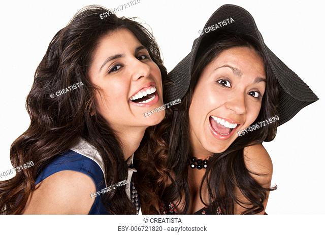 Laughing Hispanic sisters over isolated white background