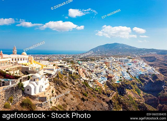 Cityscape of Fira, dramatically located on the edge of the caldera cliff on the island of Thira known as Santorini, Greece. Panorama shot