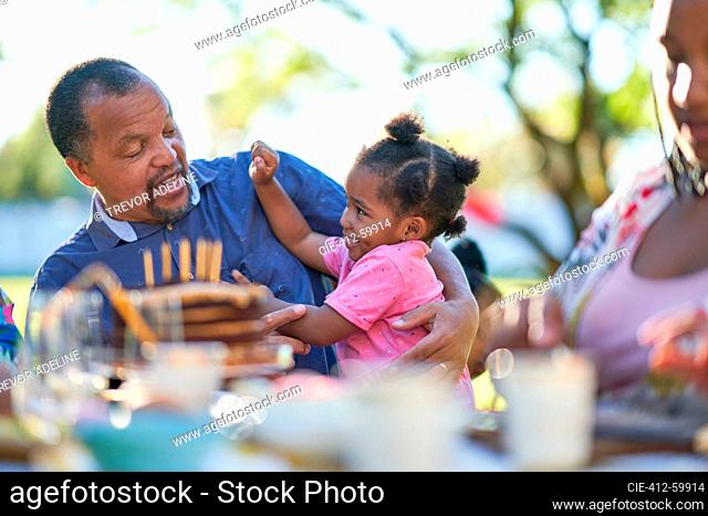 Granddaughter and grandfather at patio table