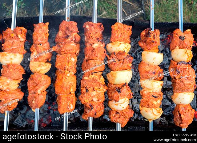 Photo cooking fry shish kebab, BBQ, barbecue, shashlik or meat on coals. Cooking meat in the grill on skewers in nature in the summer on a picnic