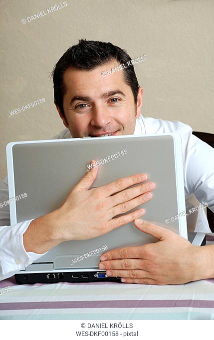 Young man with laptop, portrait