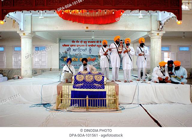 Priests accompanied by musicians in their  continues intonation of the Sri Akhandpath ; nonstop reading of the Gurugranth sahib that goes on for over 70 hours...
