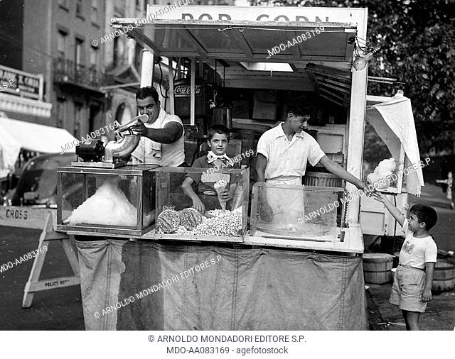 Boy buying some candy floss. Boy buying some candy floss at a food stall run by Italian Americans in a street of Little Italy. New York, 1950s
