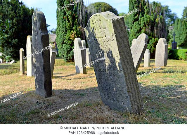 Numerous lobsided historic tombstones standing on Nieblum's cemetery beside the church St. Johannis, 2 August 2018 | usage worldwide