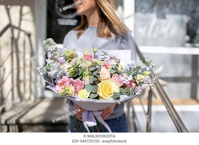 bouquet of beautiful flowers in women's hands. Floristry concept. Spring colors. the work of the florist at a flower shop
