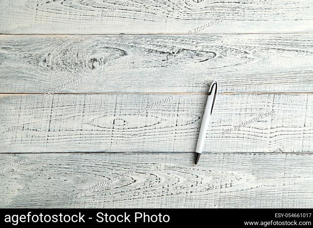 white pen on vintage shabby white wooden background. the view from the top. flat lay