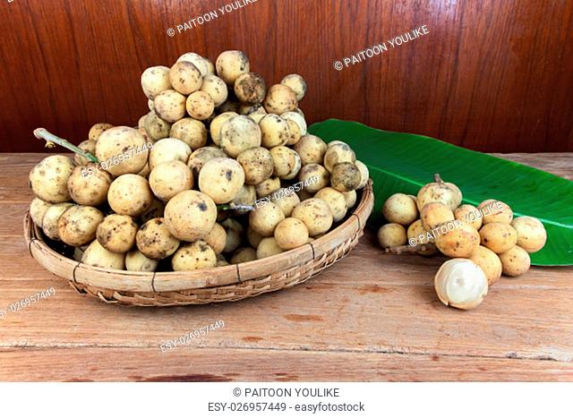 Longkong, Langsat or Lanzones fruit piled in a basket on wood table