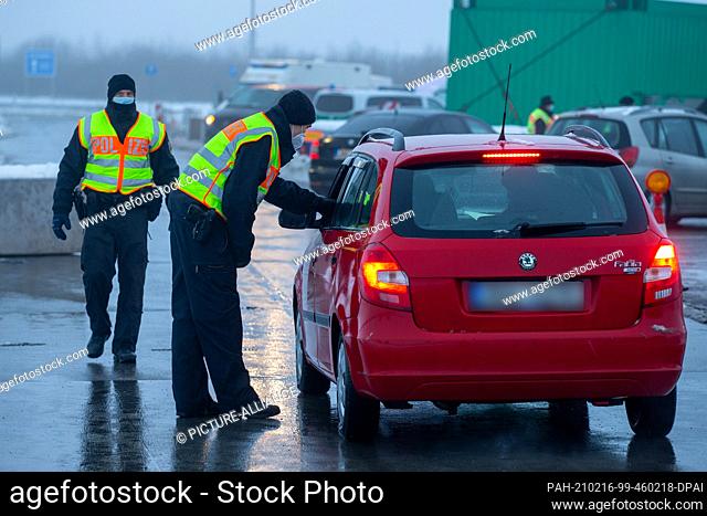 16 February 2021, Saxony, Breitenau: Two police officers of the Federal Police checking travellers and commuters at the parking lot Am Heidenholz on the A17...