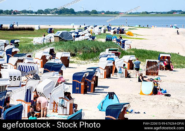15 June 2022, Lower Saxony, Hooksiel: Numerous tourists sit in their beach chairs on the beach in sunny weather. The North Sea Tourism Day 2022 is taking place...
