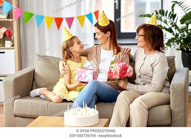 daughter with gift box greeting mother on birthday