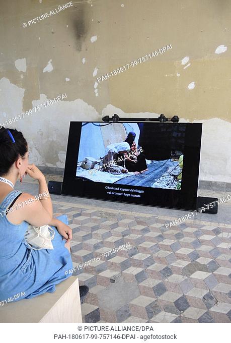 16 June 2018, Palermo, Italy: A visitor looks at a video installation by Erkan Oezgen shown during the Manifesta 12 at the Palazzo Forcella De Seta in Palermo