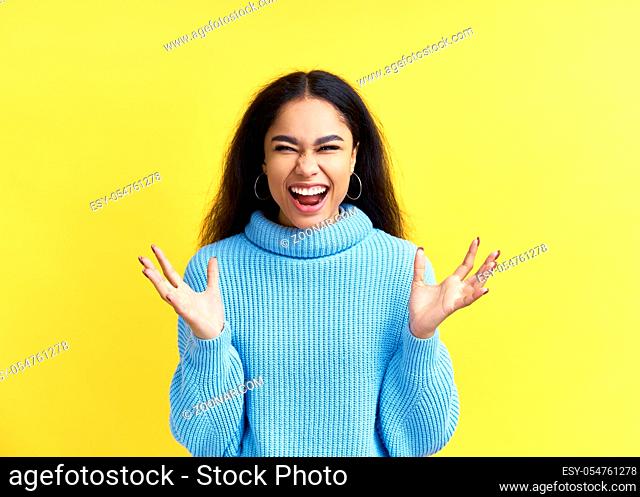 Happy excited black woman celebrate success isolated on yellow background. Victory, emotions concept