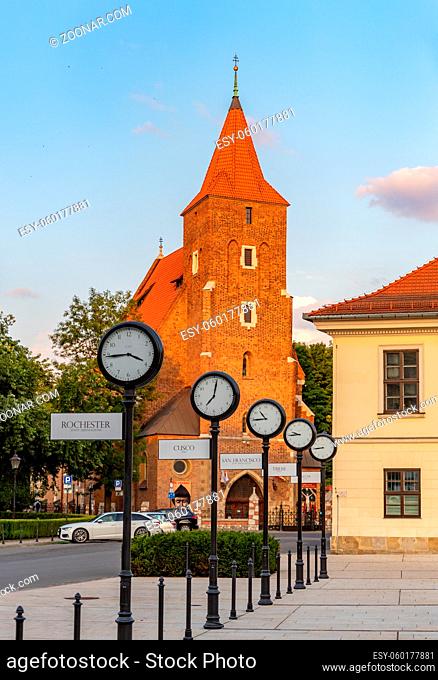A picture of the city clocks on the Holy Spirit Square and the Roman Catholic Parish of the Holy Cross
