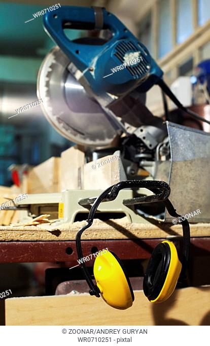 plywood circular saw and protective earphones
